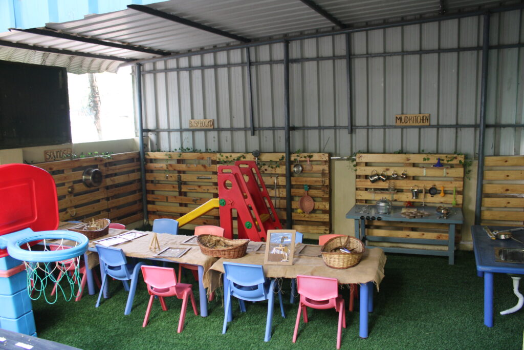 A vibrant mud kitchen setup in a colorful outdoor play area designed for young children