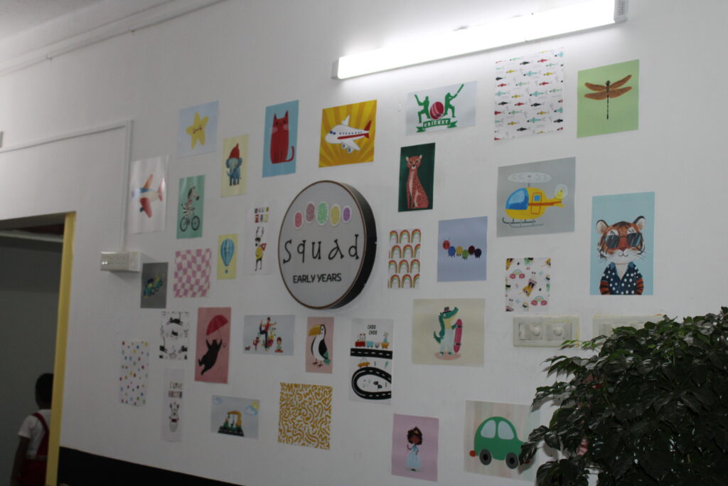 logo at the center, surrounded by colorful children’s artwork, symbolizing creativity and community spirit