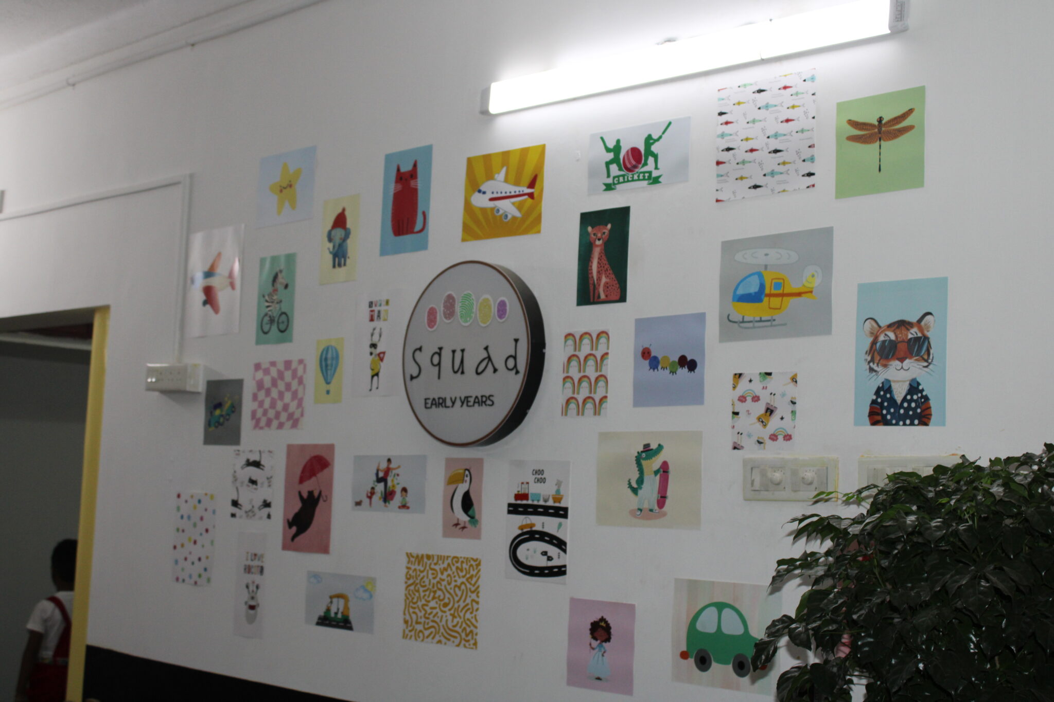 logo at the center, surrounded by colorful children’s artwork, symbolizing creativity and community spirit